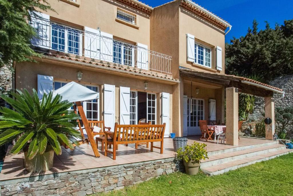 a house with a patio with a table and chairs at Maison du Baou - Welkeys in Toulon