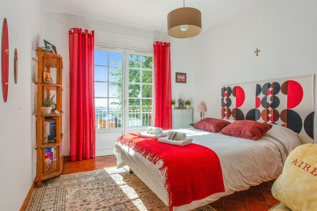 a bedroom with a large bed with red curtains at Maison du Baou - Welkeys in Toulon