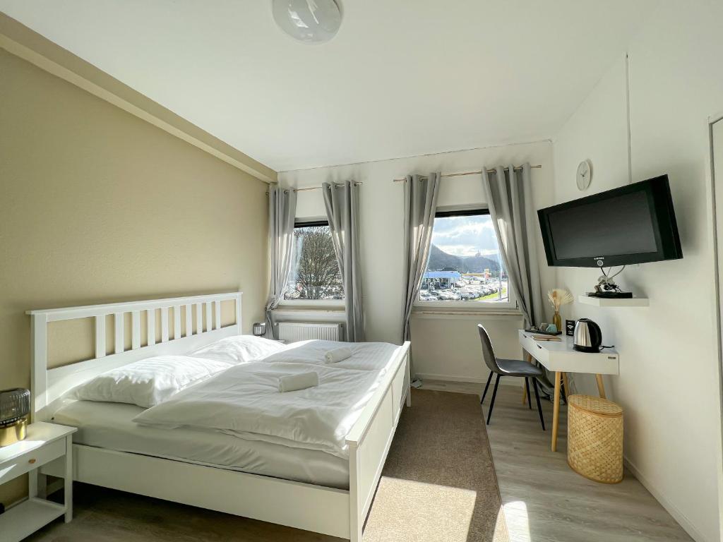 a bedroom with a bed and a desk and a television at Magaré Hotel & Restaurant in Lahnstein