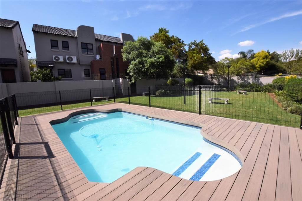 a large swimming pool on a deck next to a building at Elroys in Sandton