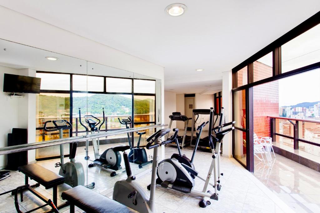 um ginásio com equipamento cardiovascular num edifício com janelas em Blue Tree Towers Joinville em Joinville