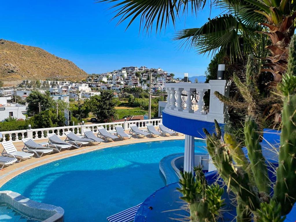 a swimming pool with lounge chairs and a resort at ASPAT HOTEL BODRUM - Beach&Restaurant in Bodrum City