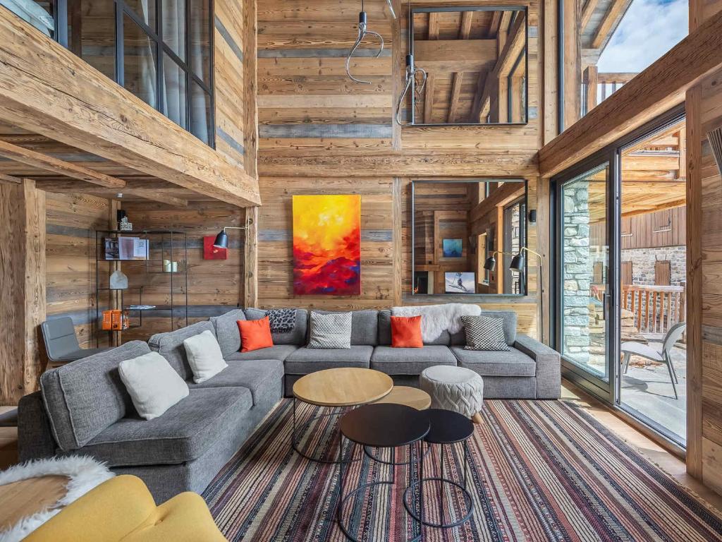 a living room with a couch and a table at Chalet d'Exception avec Piscine, Hammam et Ascenseur à Val d'Isère, Proche des Pistes - FR-1-567-38 in Val dʼIsère