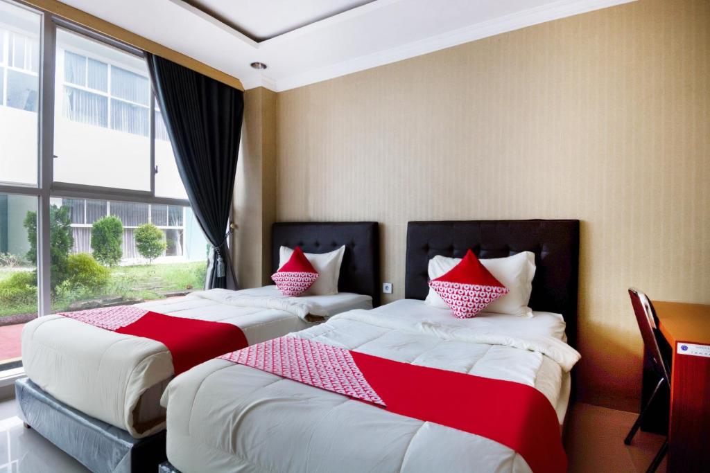 Postel nebo postele na pokoji v ubytování Super OYO Collection O 3431 Hotel Alpha Bandara