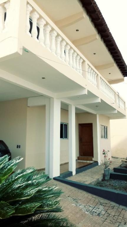 Casa blanca con escalera y patio en Parque Mãe Bonifácia-Sobrado 4 suítes com ar e piscina en Cuiabá