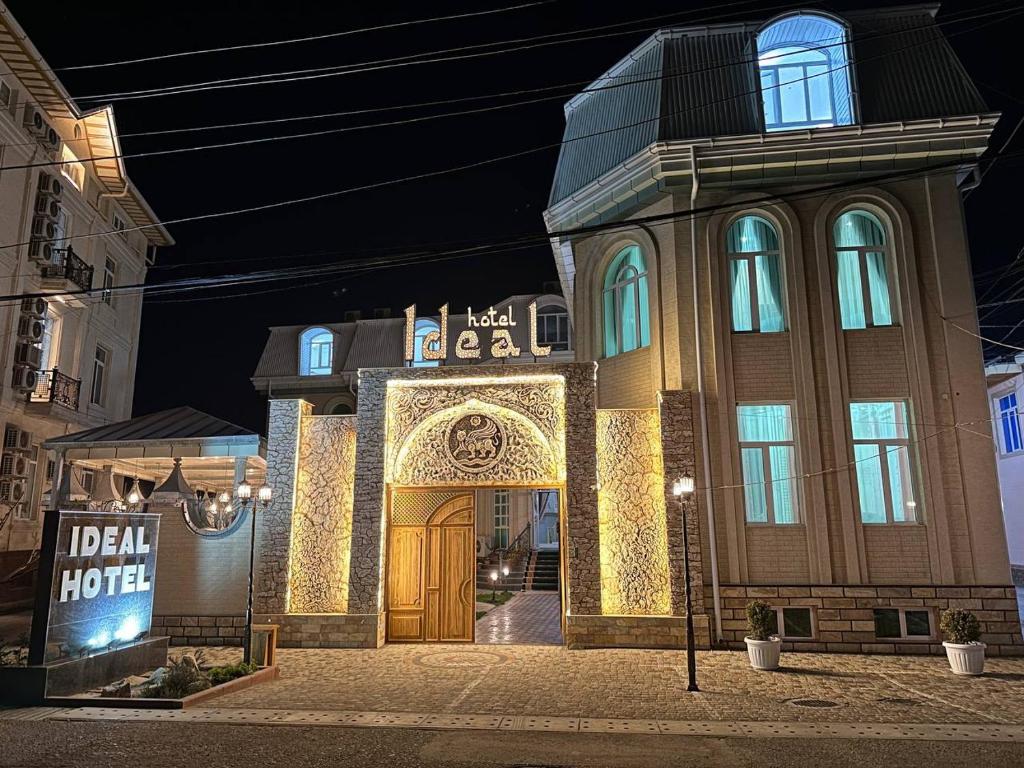a building with a golden door in a city at night at Ideal Hotel in Samarkand
