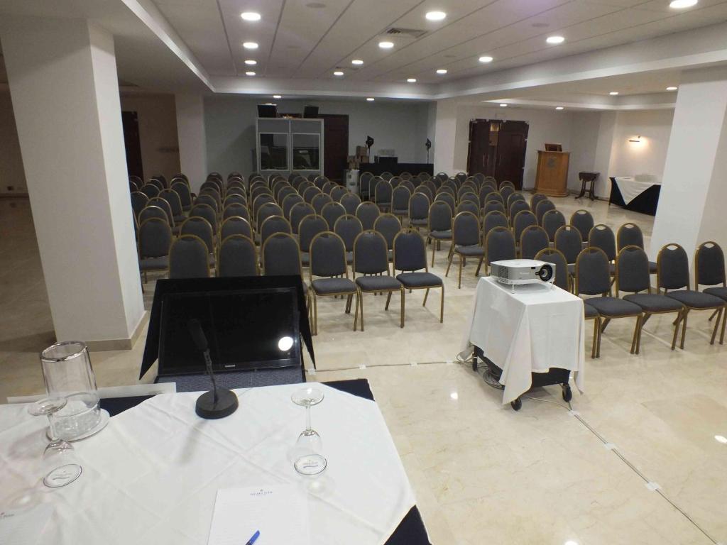 a large room with chairs and a stage with a podium at Vivaldi Hotel in St. Julianʼs