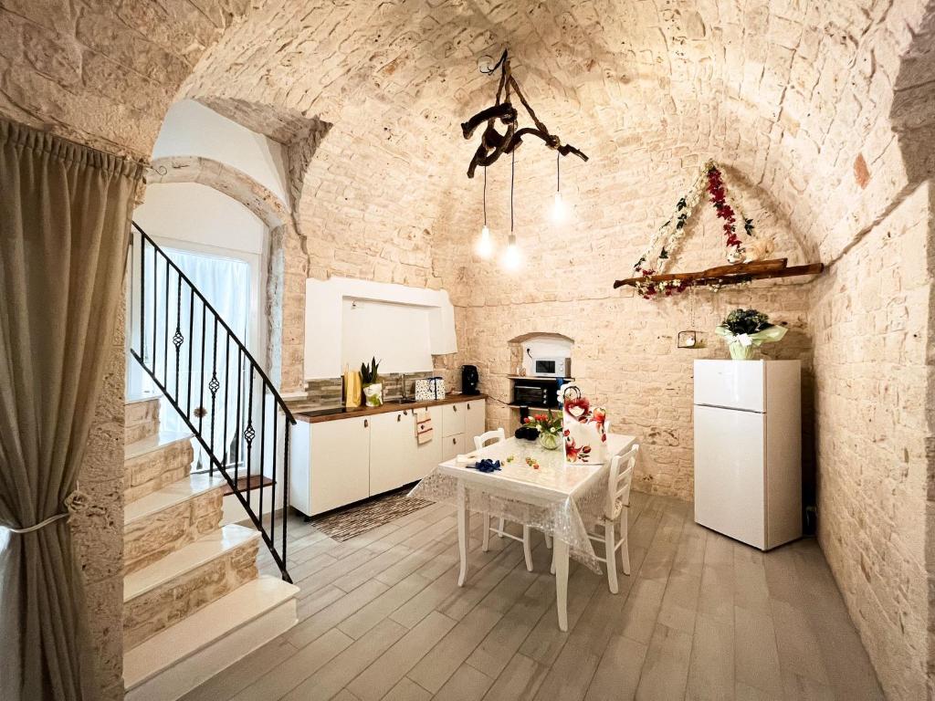 une cuisine et une salle à manger avec un mur en briques dans l'établissement Meraviglie del Sud, à Castellana Grotte