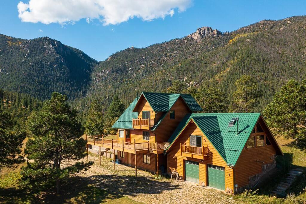 a log cabin in the mountains with a green roof at Stunning 360° Views - Hiker's Paradise! in Cascade-Chipita Park
