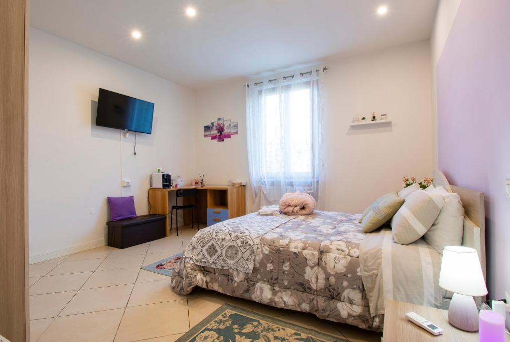 Schlafzimmer mit einem Bett, einem Schreibtisch und einem Fenster in der Unterkunft B&B Le Rose di Gori Cristina in Pistoia