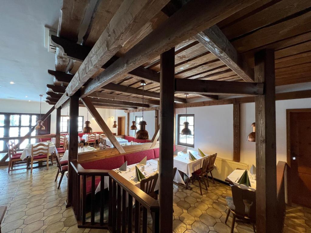 ein Restaurant mit Tischen und Stühlen und einem Boot in der Unterkunft Hotel Der Distelhof in Dillstädt