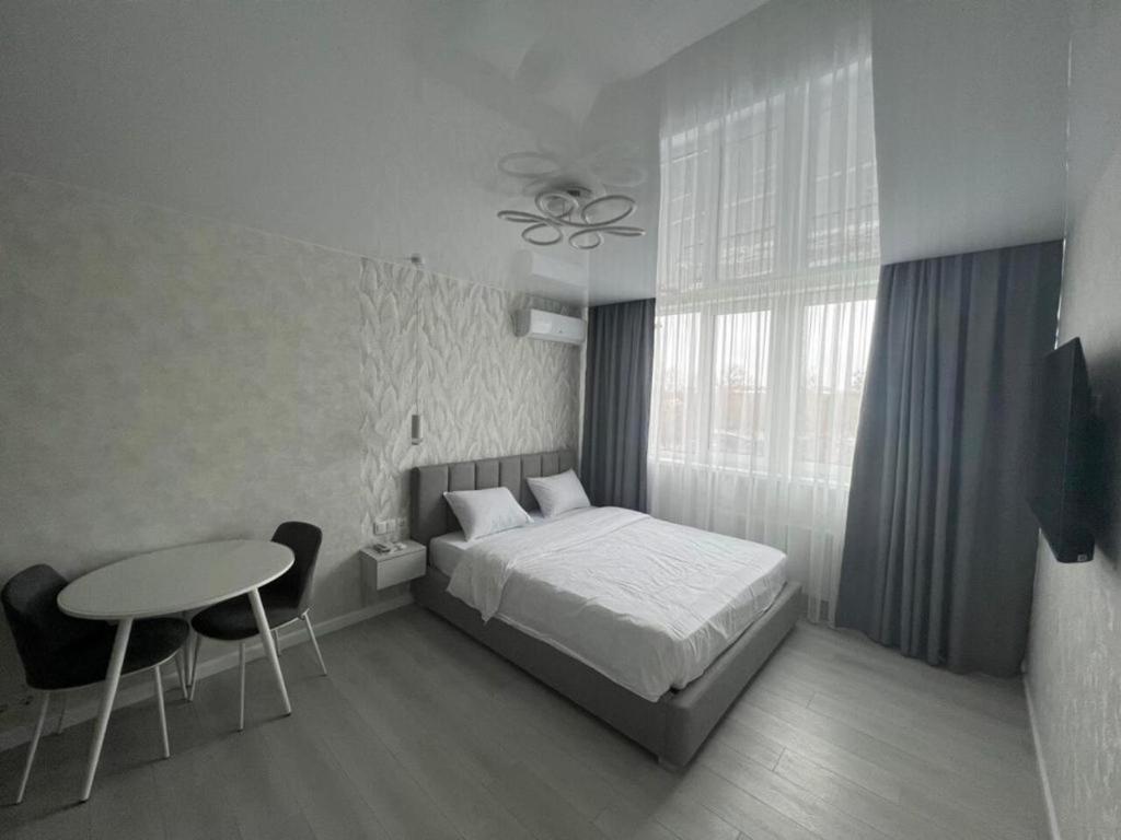 a bedroom with a bed and a table and a window at Deluxe apartments - Viva Ukraine in Kyiv