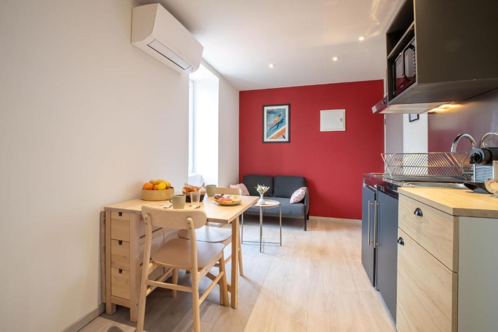 eine Küche mit einem Tisch und einem Esszimmer in der Unterkunft La Source aux Cépages in Santenay