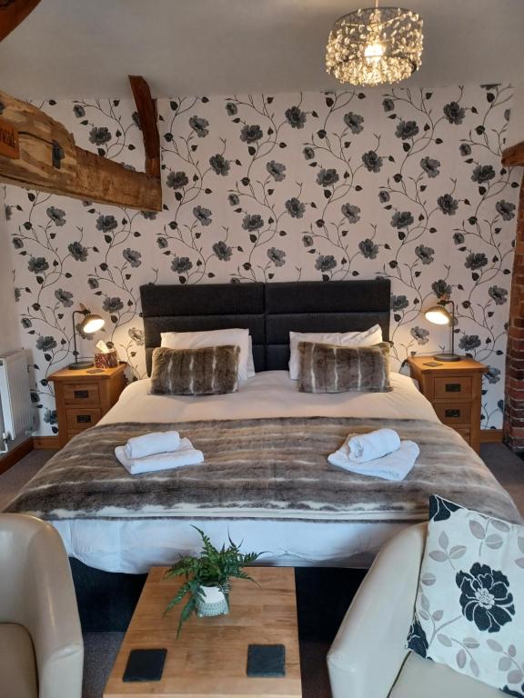 a bedroom with a large bed with a table at The Bear in Rhayader