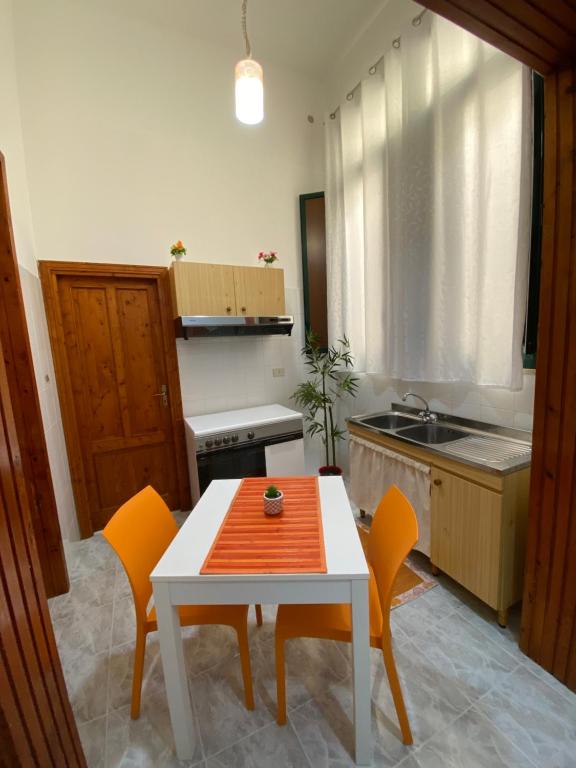 a kitchen with a table and chairs and a sink at Apartment Roasi in Trapani