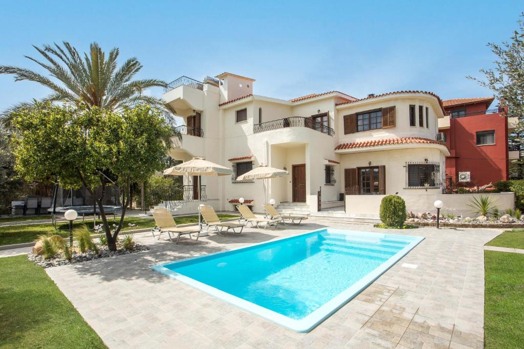 a villa with a swimming pool in front of a house at Hriska Luxury Villa in Ixia