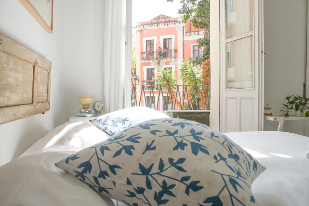 a bedroom with a bed with a pillow and a window at Sa Prazza GuestHouse in Cagliari