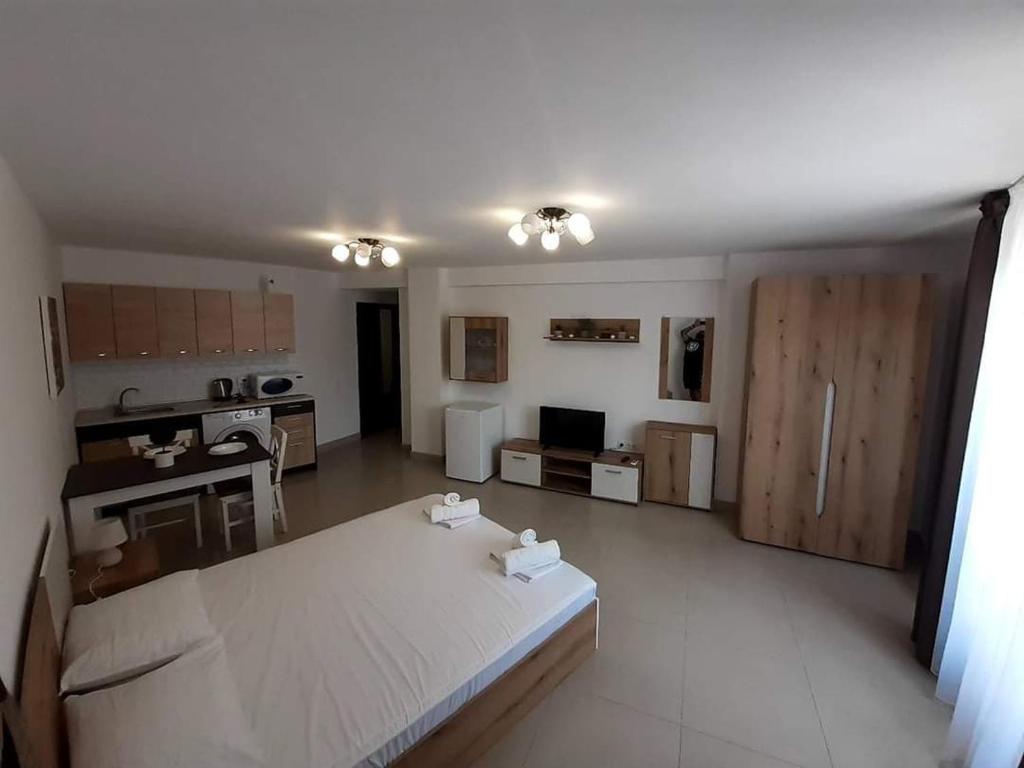 uma ampla sala de estar com uma cozinha e uma mesa em Апартамент Quattro em Dobrich