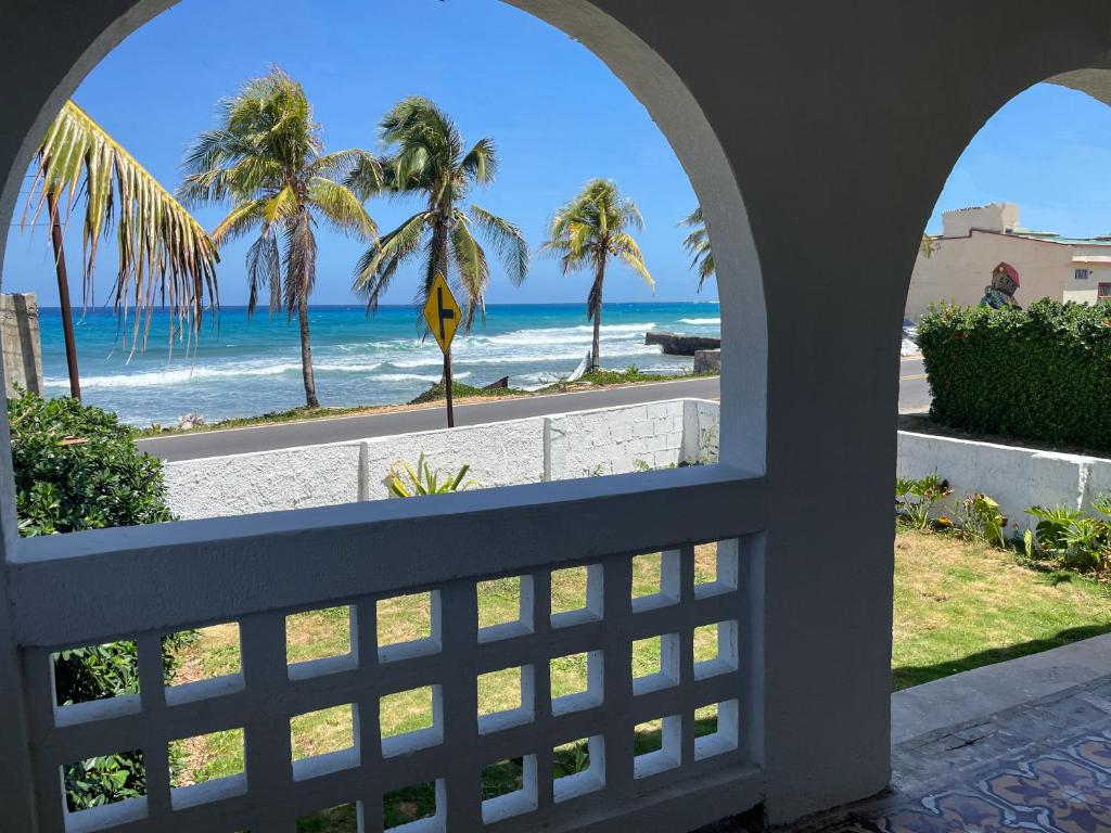 Blick auf den Strand von einem Fenster des Hauses in der Unterkunft Puesta del Sol Guest House in San Andrés