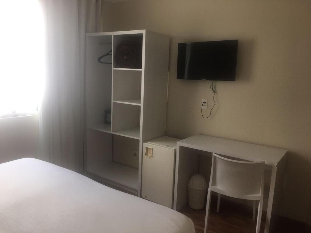聖安娜－利弗拉門圖的住宿－Emirates Hotel & Suites，一间卧室配有一张床和一张书桌及电视