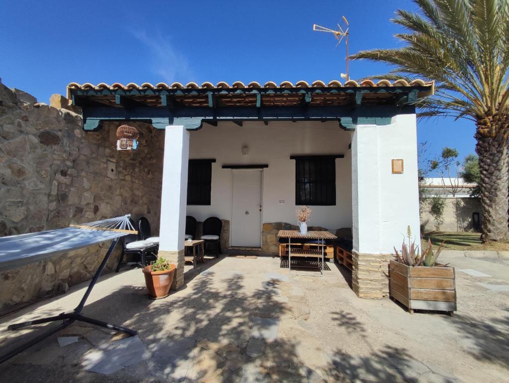 Cette petite maison dispose d'une terrasse et d'un palmier. dans l'établissement Casa Portal, à El Palmar