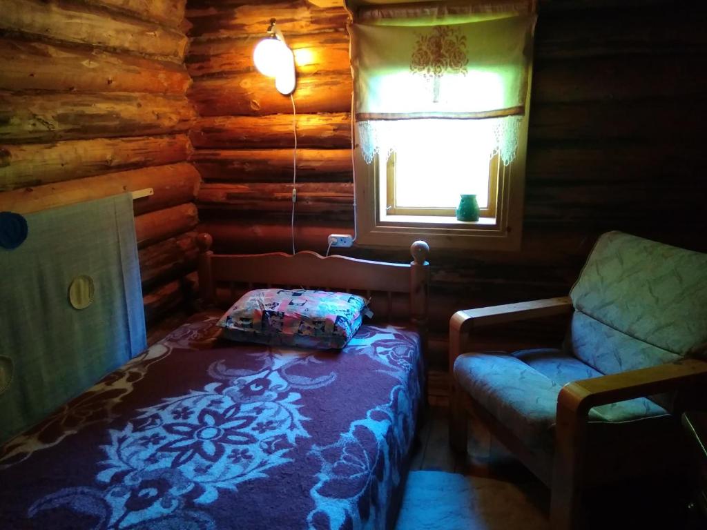 ルースメにあるPähnamäe metsamajakeのベッドルーム1室(ベッド1台、椅子付)