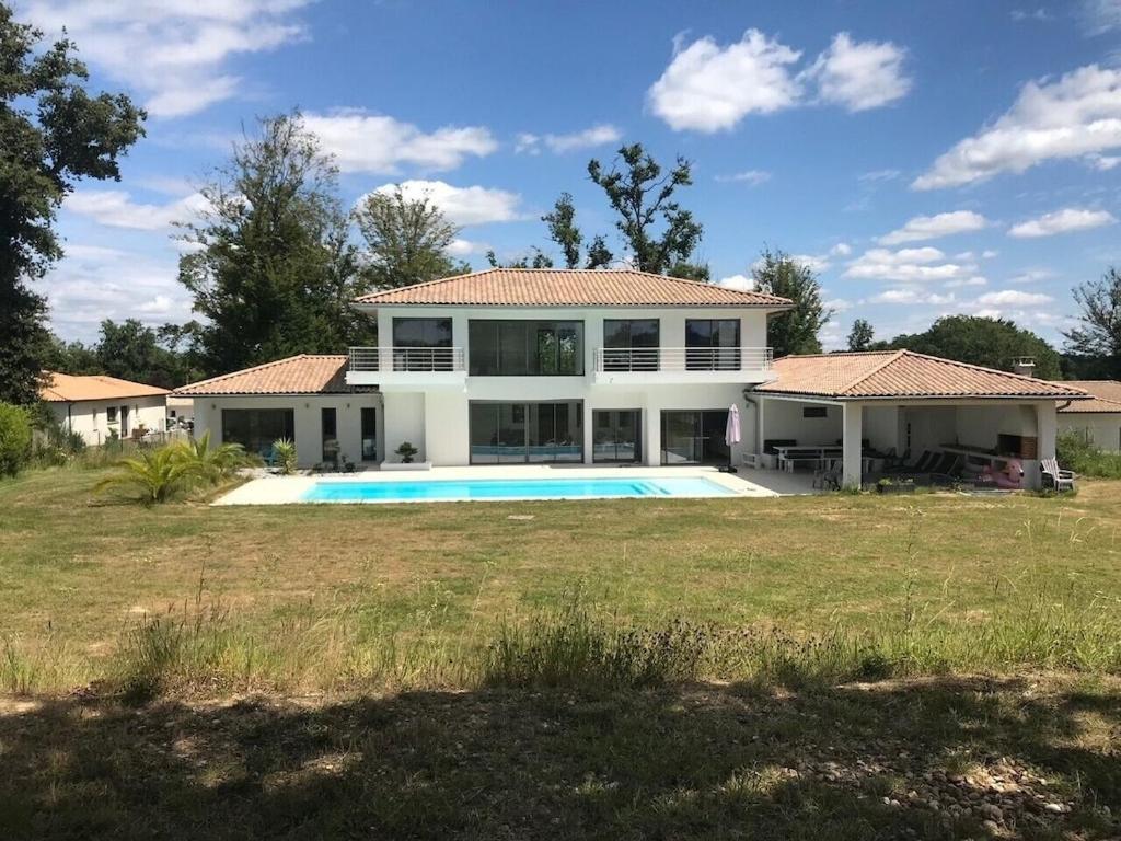 une maison avec une piscine dans une cour dans l'établissement Villa Cenac d architecte vue vignoble proche Bordeaux, à Cénac