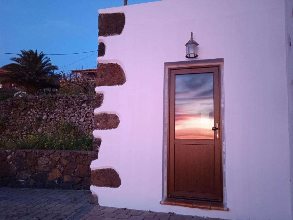 una puerta en un edificio con una puesta de sol en la ventana en Casa Ben Abora, en Las Rosas