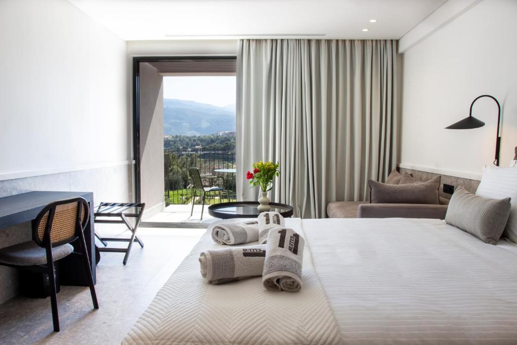 um quarto de hotel com uma cama com toalhas em 11Suites em Aigio