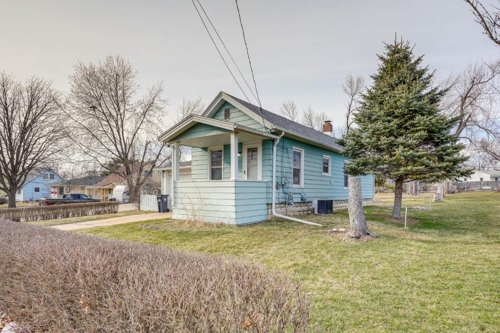 uma casa azul com uma árvore no quintal em Cedar Rapids Vacation Home Near Downtown District! em Cedar Rapids