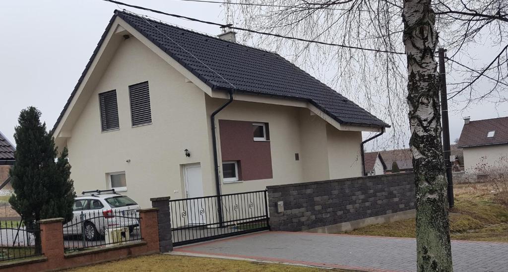 una casa blanca con techo negro y valla en Blatnica Bee494 Apartment, en Blatnica