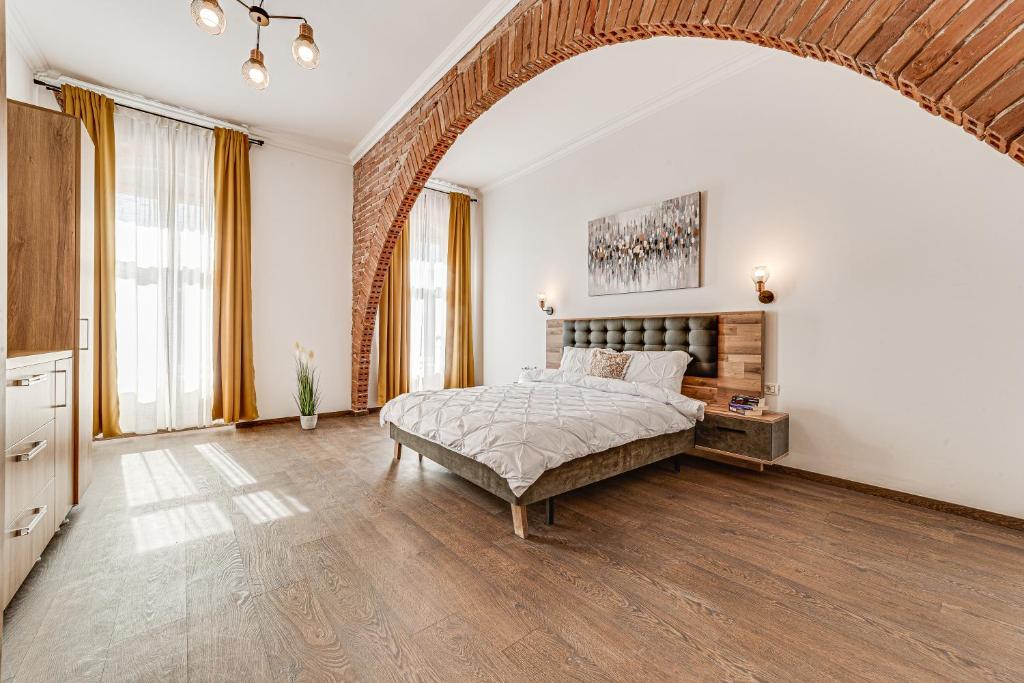una grande camera da letto con un letto e una grande finestra di ARI Central Grand Apartment a Arad