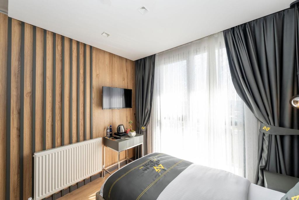 a bedroom with a bed and a window at Heaven Inn Airport Hotel in Arnavutköy
