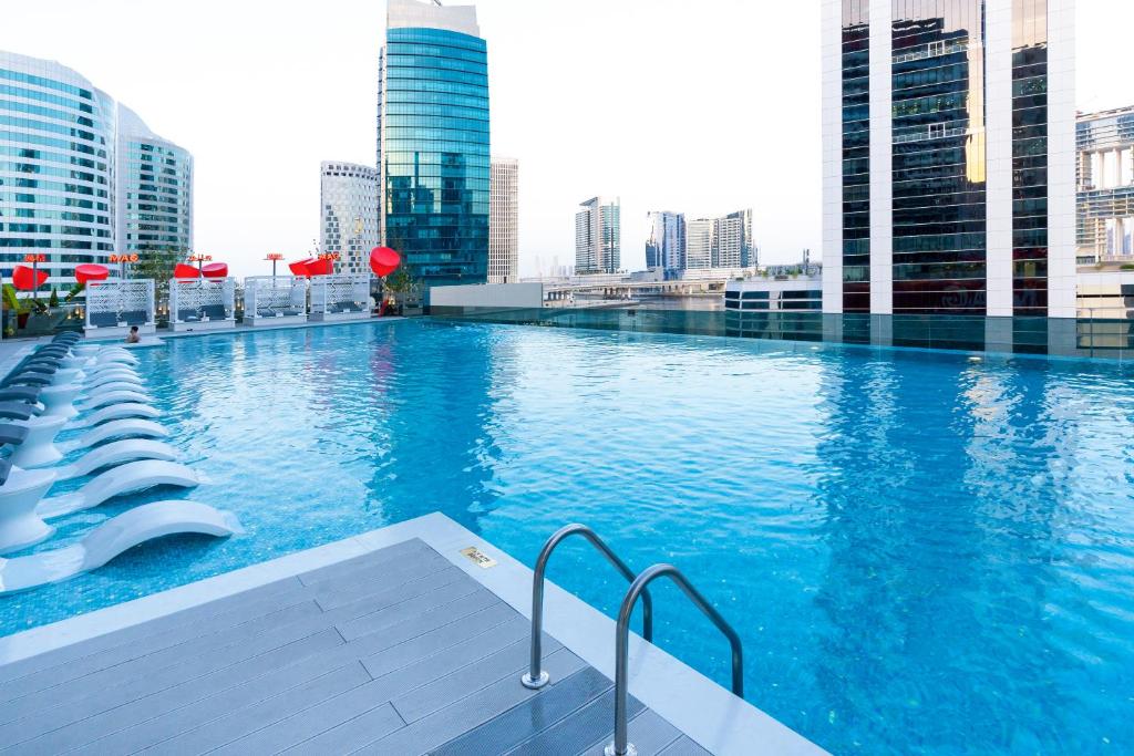 a swimming pool on top of a building with tall buildings at Lux Studio in Downtown, 5 mins to Burj Khalifa & Dubai Mall - MAG318 in Dubai