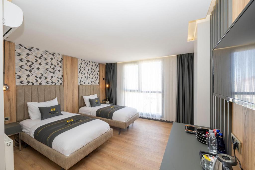 a hotel room with two beds and a television at Heaven Inn Airport Hotel in Arnavutköy