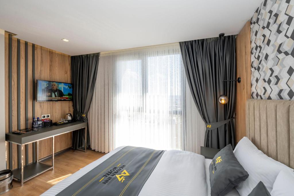 a hotel room with a bed and a television at Heaven Inn Airport Hotel in Arnavutköy