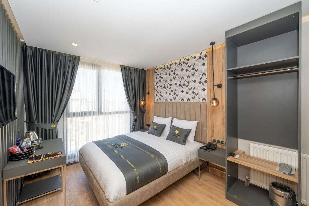 um quarto com uma cama grande e uma televisão em Heaven Inn Airport Hotel em Arnavutköy