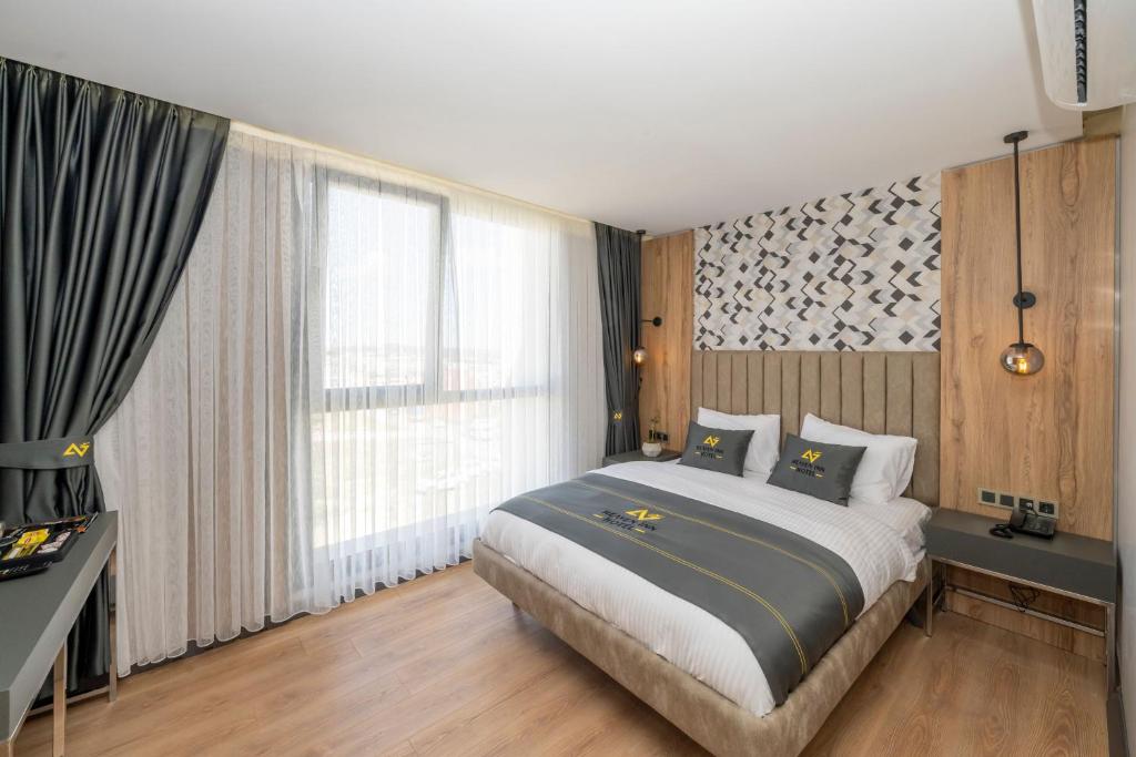a bedroom with a bed and a large window at Heaven Inn Airport Hotel in Arnavutköy