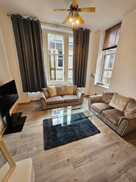 a living room with two couches and a glass table at 65 Renfield st 2 bed Apartment in Glasgow