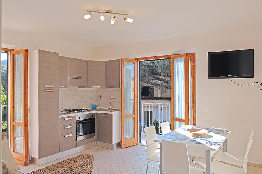 a kitchen and dining room with a table and a television at Appartamenti Casa Pineta in Marina di Campo