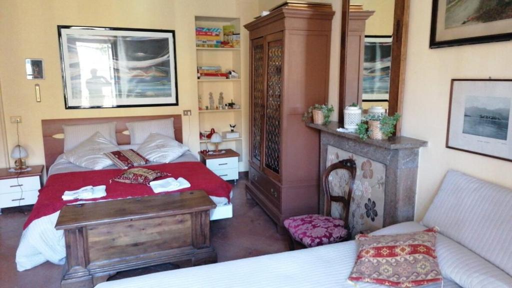 a bedroom with a red bed and a fireplace at Giò's House vintage style in Stresa