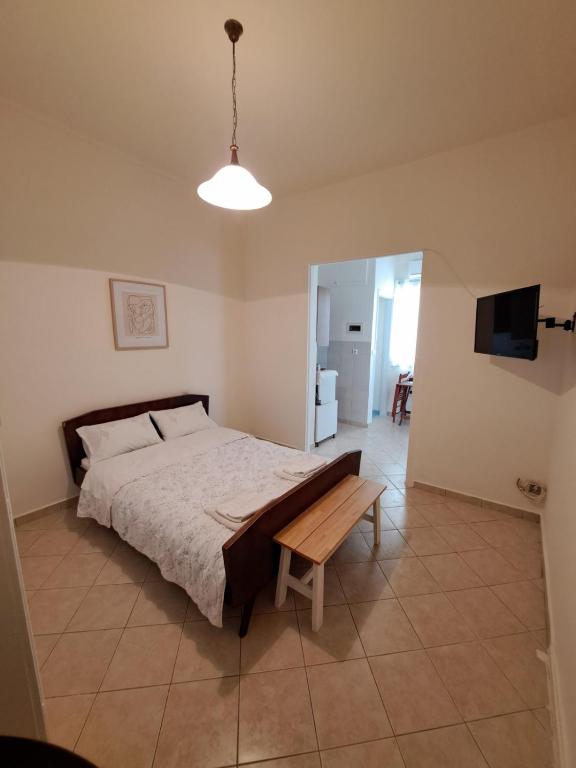 1 dormitorio con cama y mesa de madera en Persefoni's Room en Néa Kíos