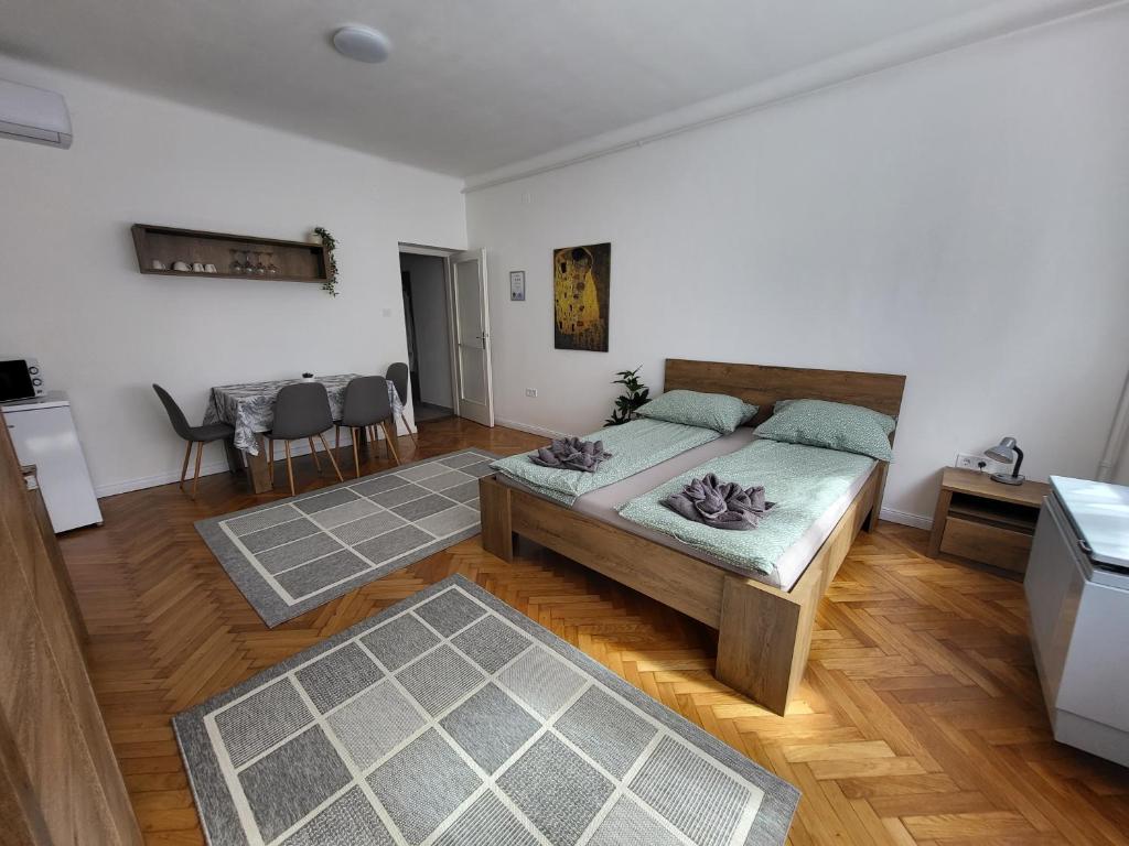 una camera con letto, tavolo e sedie di Downtown Studio Apartman a Pécs