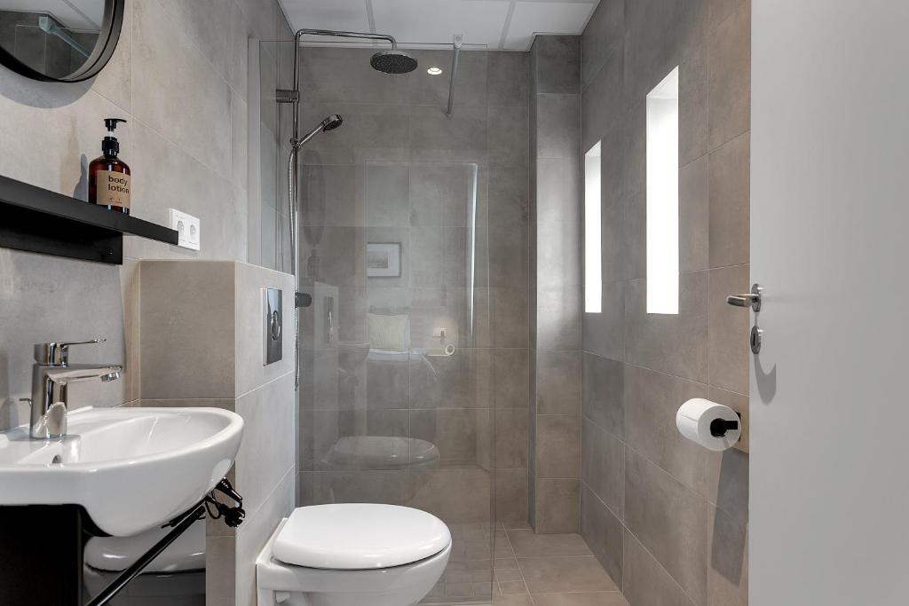 y baño con aseo, lavabo y ducha. en NN Urban Guesthouse, en Reikiavik