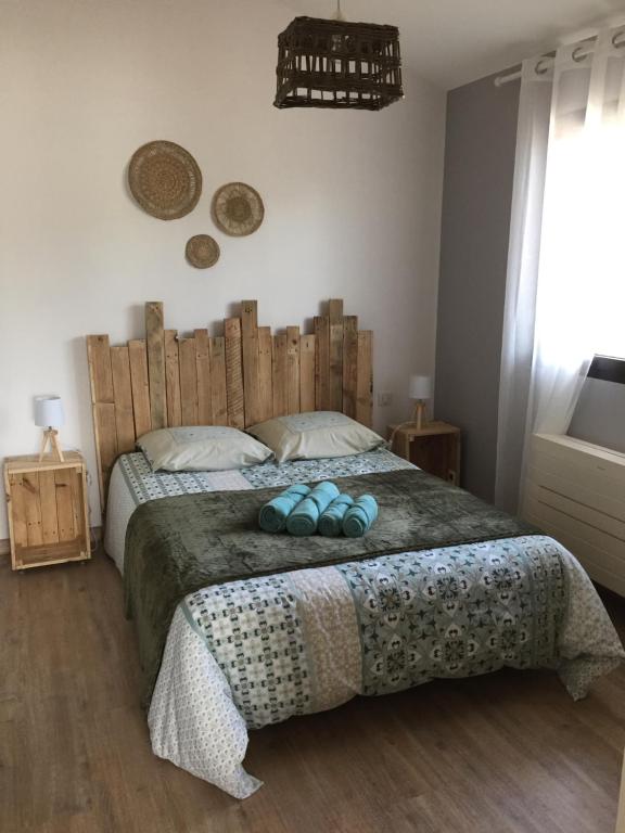 a bedroom with a large bed with a wooden headboard at Le chat perché in Saint-Julien-en-Born