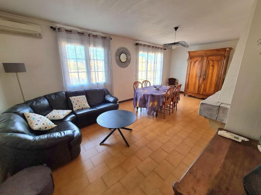 sala de estar con sofá de cuero negro y mesa en Chez Nelly en La Seyne-sur-Mer