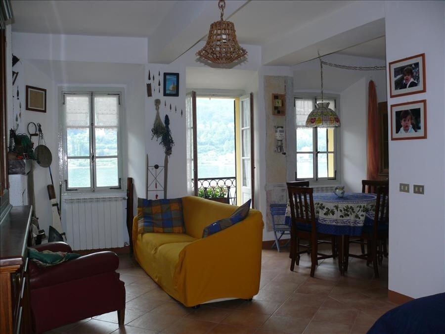 Appartamento Olga في ستريزا: غرفة معيشة مع أريكة صفراء وطاولة