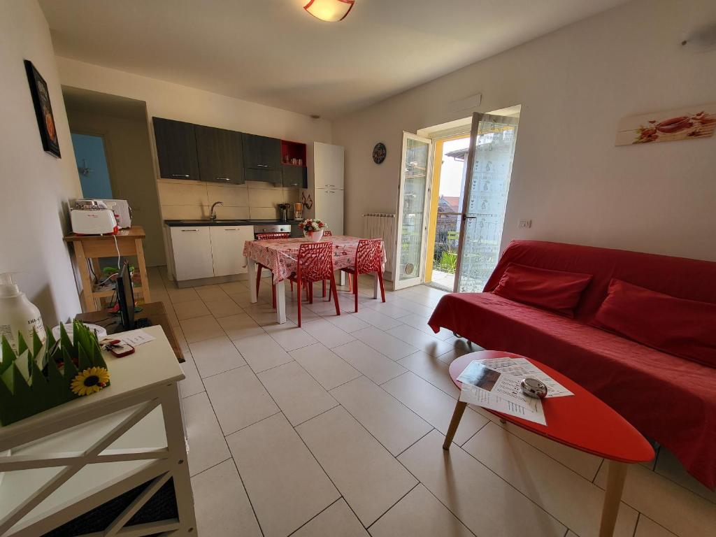 a living room with a red couch and a table with a surfboard at Red Apartment - Residenza Silvana in Verbania