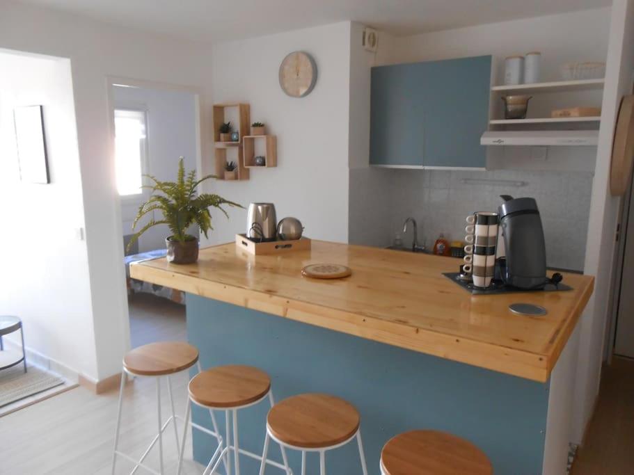 - une cuisine avec un comptoir avec tabourets et une cafetière dans l'établissement Appartement à la plage, à Argelès-sur-Mer
