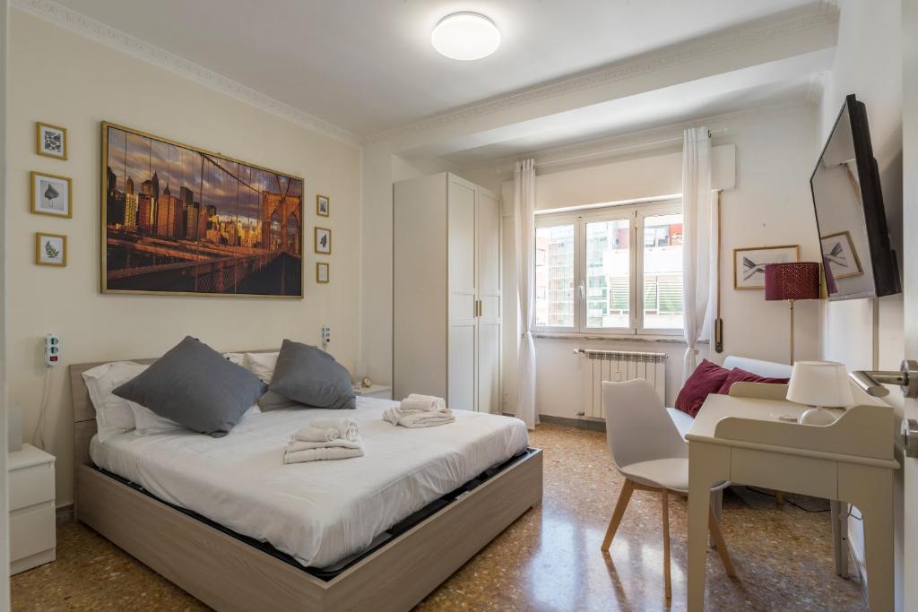 - une chambre avec un lit et un bureau dans l'établissement Cinecittà Gem Flat with Veranda, à Rome